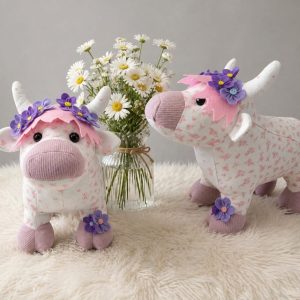 Two highland cow keepsakes in pink floral fabric with felt flower crowns and daisies
