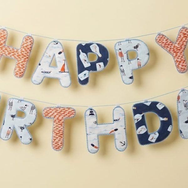 Blue patterned Happy Birthday fabric banner hung in two rows